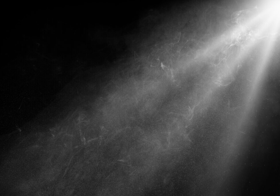 grey spotlight effect on stage or crepuscular rays or gods rays with particles isolated on black background